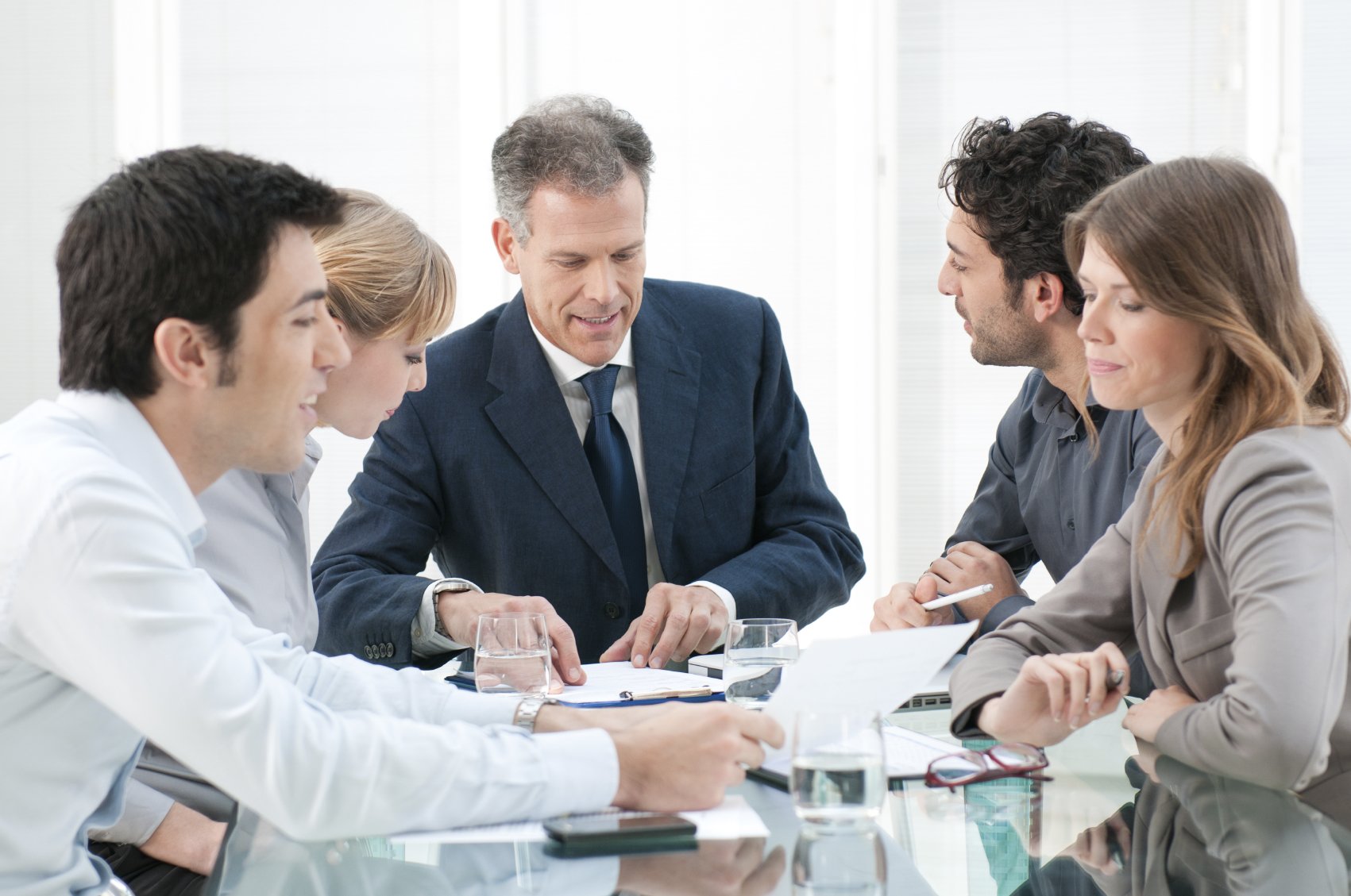 Mature businessman working and discussing with his colleagues at office