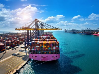 Aerial view of cargo ship and cargo container in harbor.